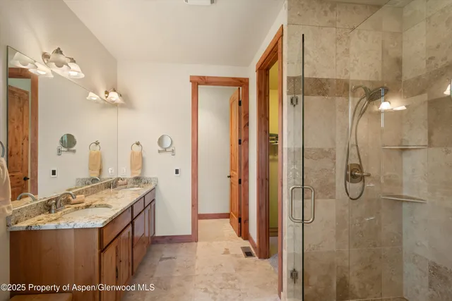 a bathroom with a granite countertop sink a mirror and shower