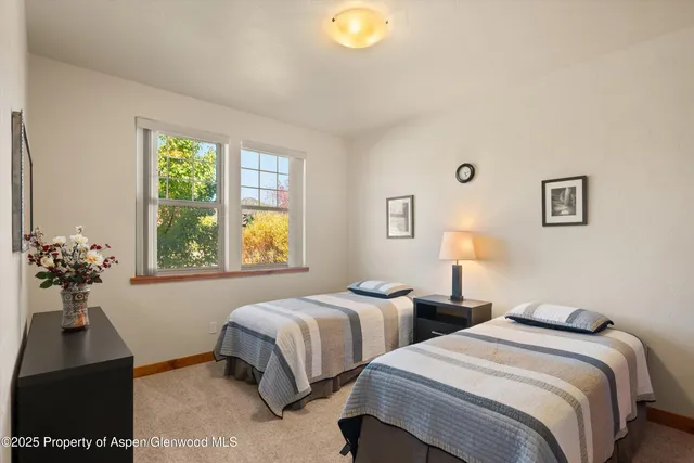 a bedroom with two beds and a potted plant