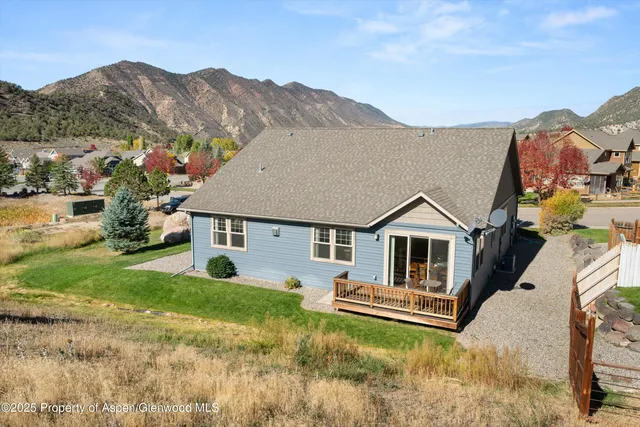 a front view of house with yard and mountain