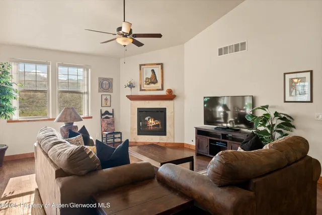 a living room with furniture a flat screen tv and a fireplace