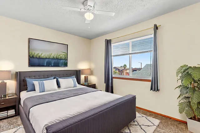 a view of a big room with windows and chandelier fan