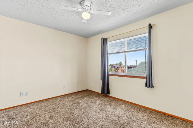 an empty room with closet and a ceiling fan