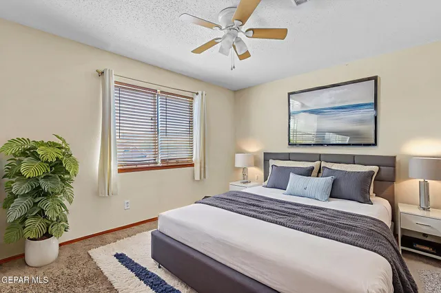 a spacious bedroom with a large bed and a flat screen tv