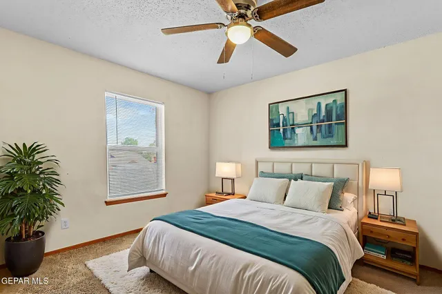 an empty room with chandelier fan and closet area