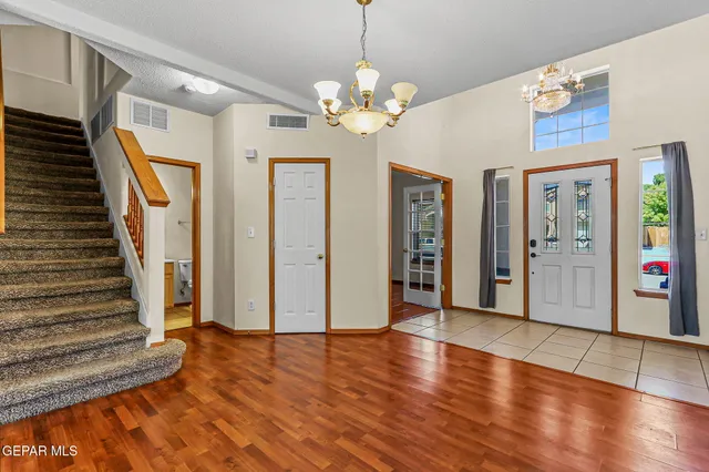 a view of an entryway with wooden floor and a chandelier