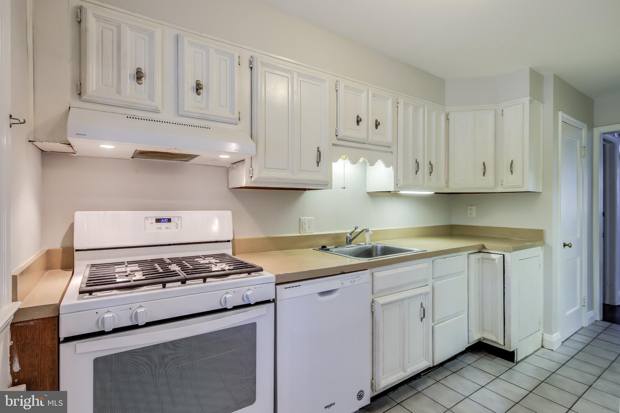 134 Cherrydell Road Baltimore, MD 21228 - Photo 12 of 36 a kitchen with granite countertop cabinets and white appliances