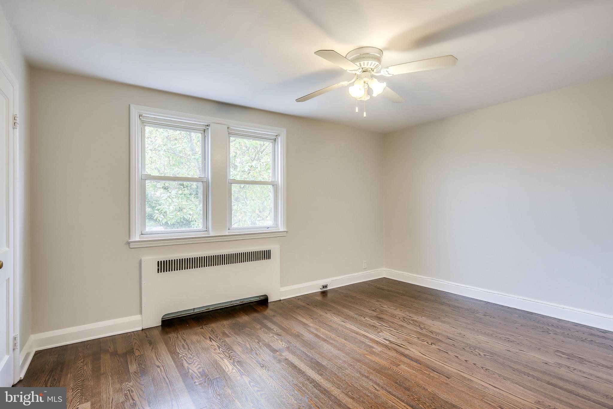 134 Cherrydell Road Baltimore, MD 21228 - Photo 28 of 36 an empty room with wooden floor and windows