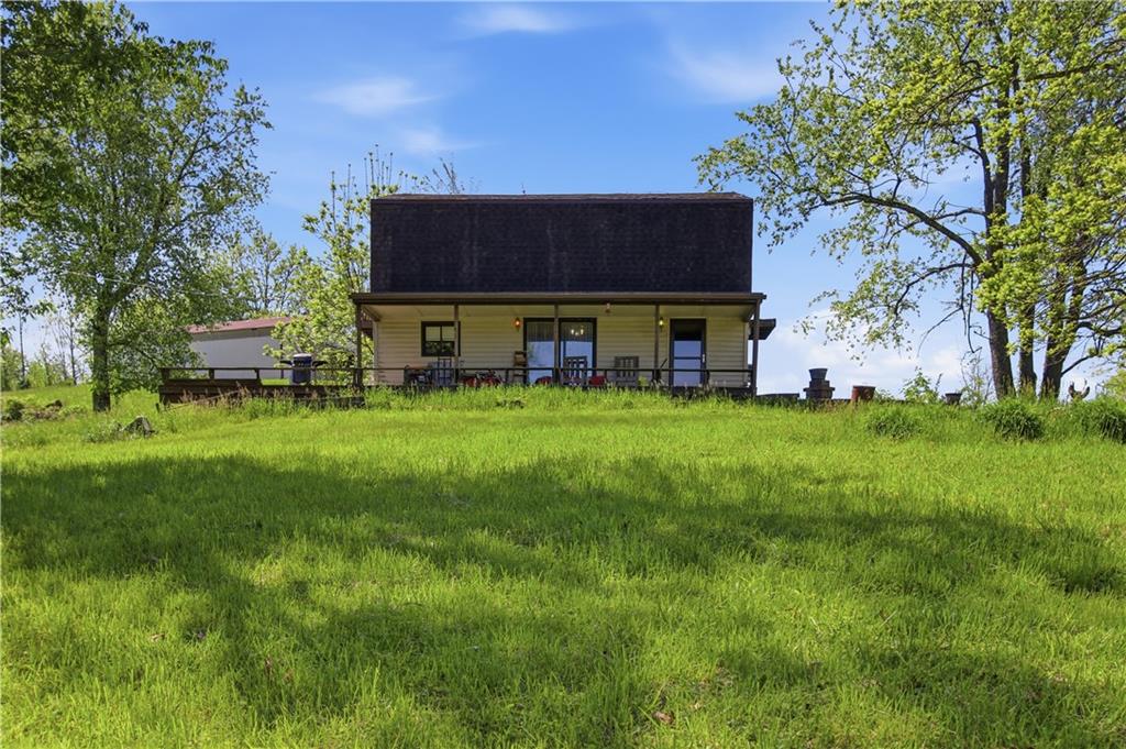 a view of a house with a big yard and large trees