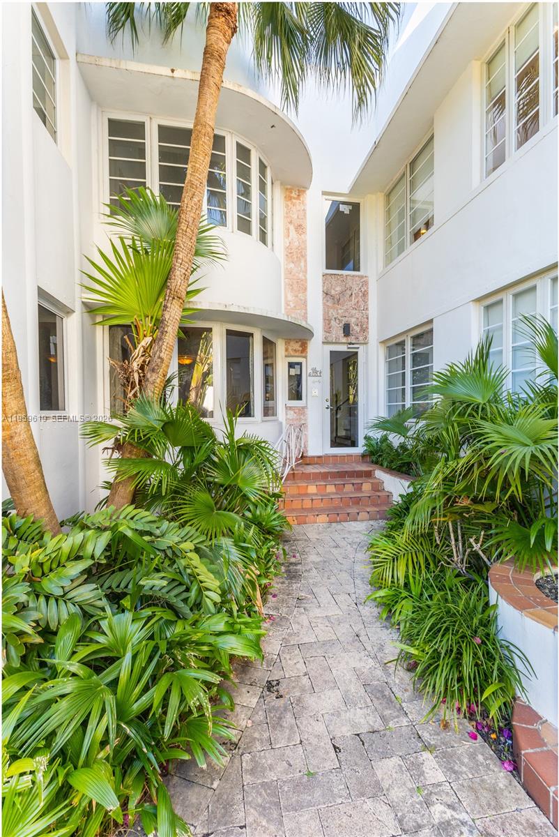 711 14th Street, Unit 4 Miami Beach, FL 33139 - Photo 16 of 27 a front view of a multi story residential apartment building with a yard and potted plants