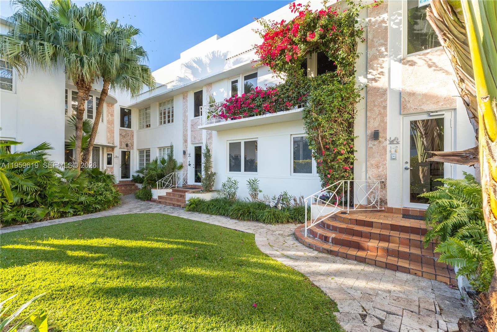 711 14th Street, Unit 4 Miami Beach, FL 33139 - Photo 2 of 27 a front view of house and yard with swimming pool and trees