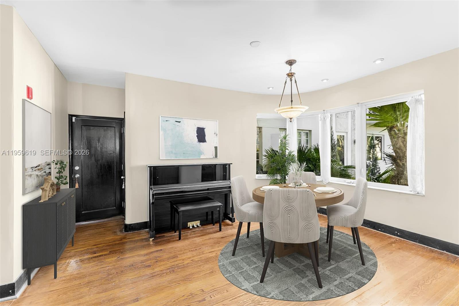 711 14th Street, Unit 4 Miami Beach, FL 33139 - Photo 4 of 27 a dining room with furniture a chandelier and wooden floor