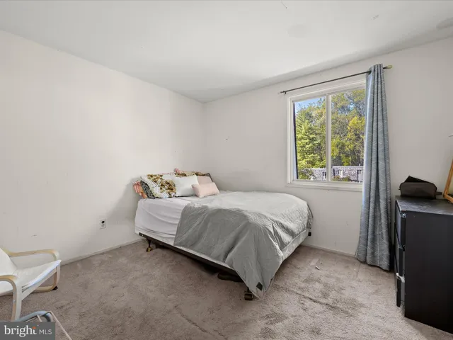 a bed sitting in a bedroom next to a window