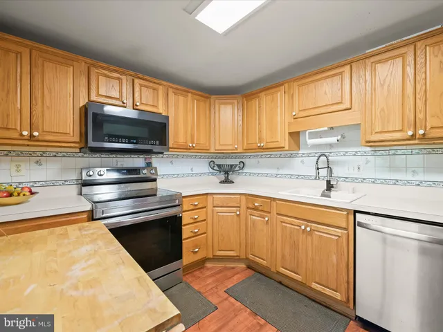 a kitchen with stainless steel appliances granite countertop a sink stove microwave and refrigerator
