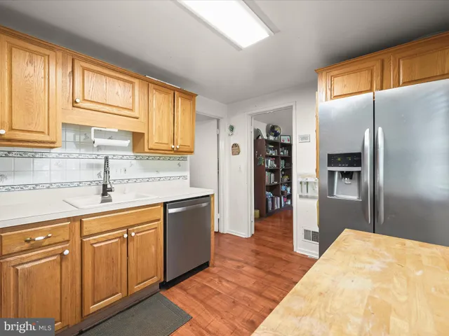 a kitchen with stainless steel appliances granite countertop a refrigerator and a sink