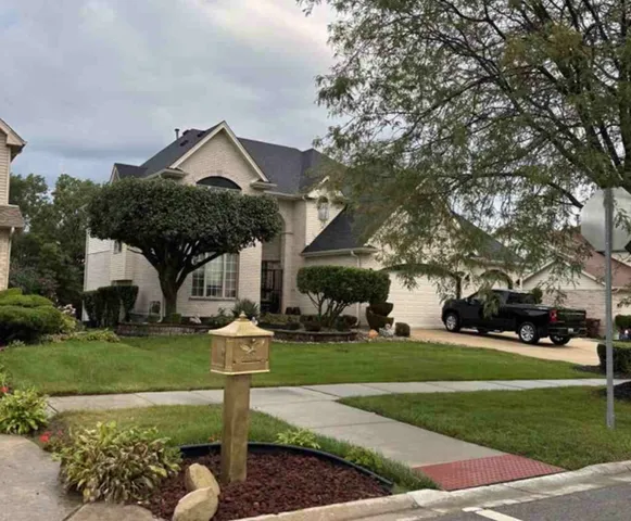 a front view of a house with a yard garden and outdoor seating