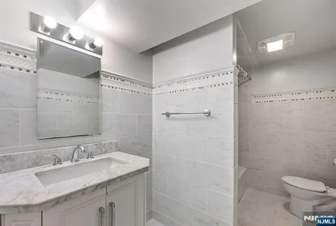 a bathroom with a granite countertop sink toilet and shower