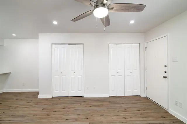 a view of an empty room with a chandelier fan