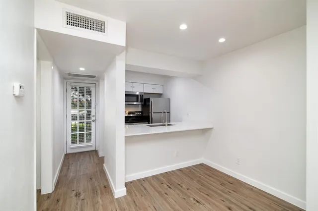 a view of kitchen with wooden floor and electronic appliances