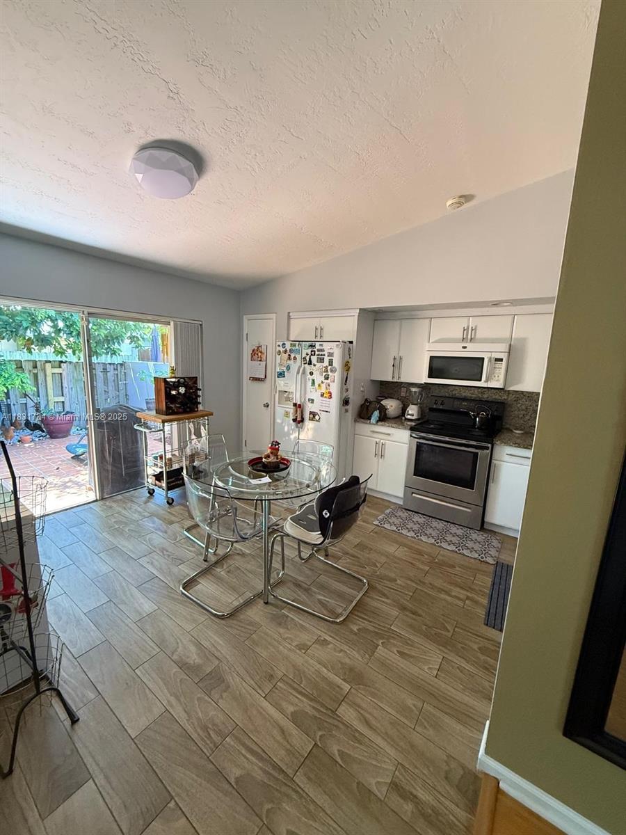 12246 Southwest 116th Lane Miami, FL 33186 - Photo 2 of 23 a view of a dining room with furniture a rug and wooden floor