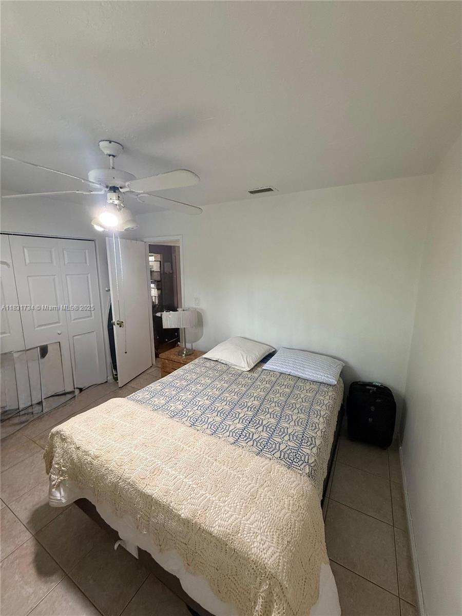 12246 Southwest 116th Lane Miami, FL 33186 - Photo 9 of 23 a bedroom with a bed and a mirror