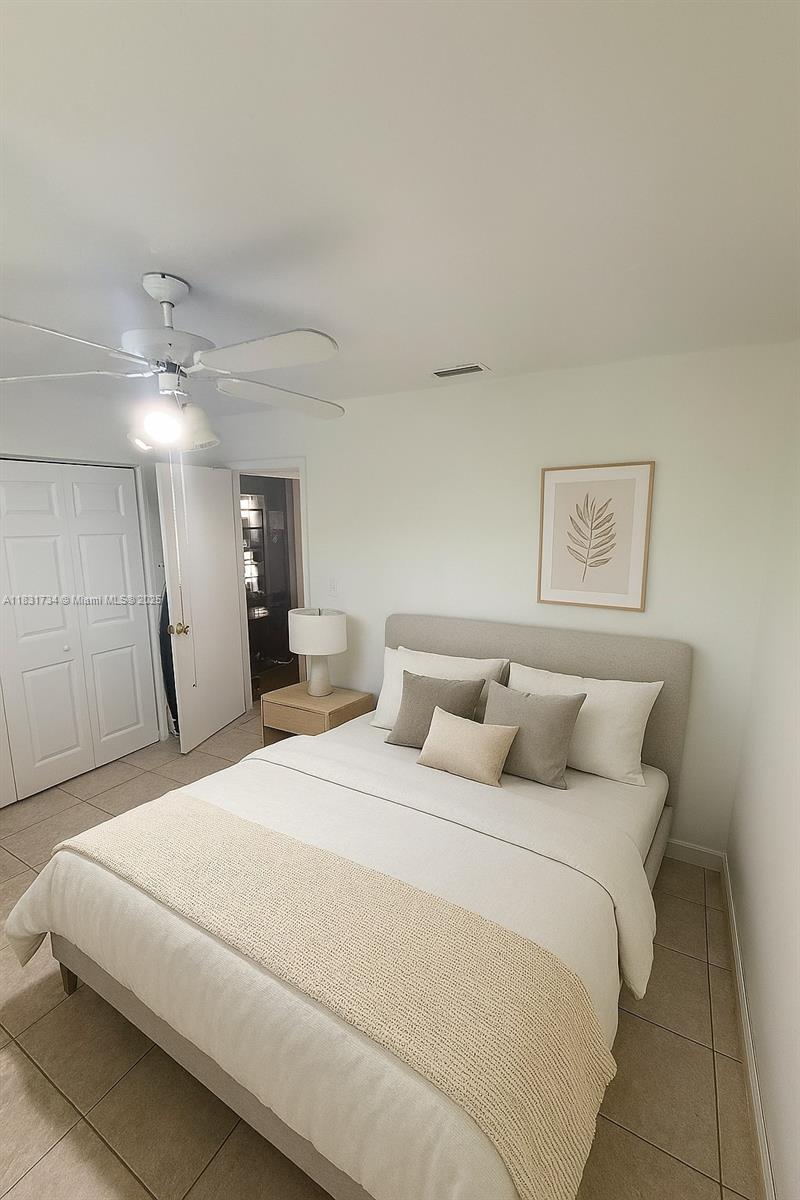 12246 Southwest 116th Lane Miami, FL 33186 - Photo 10 of 23 a bedroom with a large bed and a chandelier