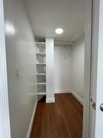 a view of a room with wooden floor and white walls