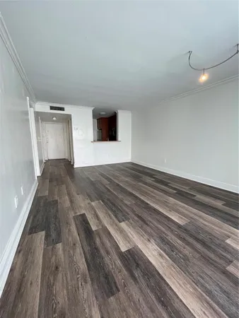 a view of empty room with wooden floor