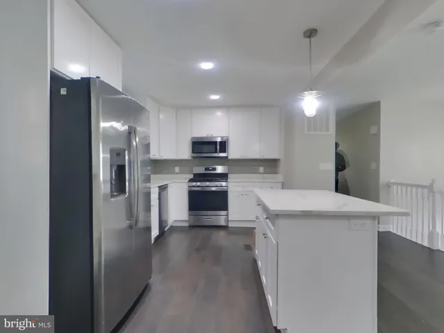 a kitchen with stainless steel appliances granite countertop a sink a stove a refrigerator and a oven