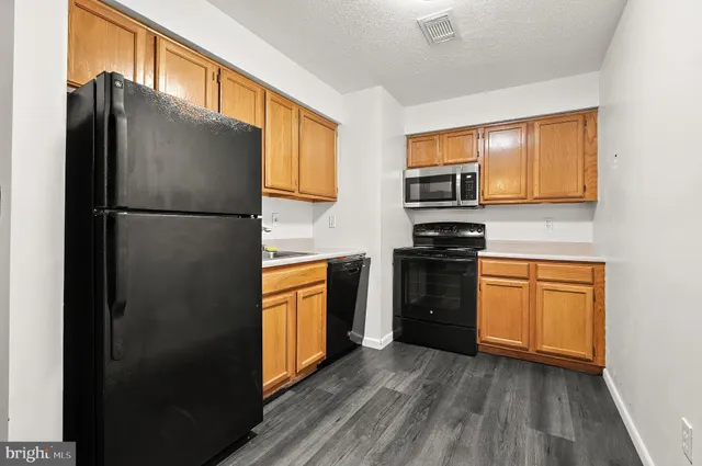 a kitchen with granite countertop a refrigerator stove and oven