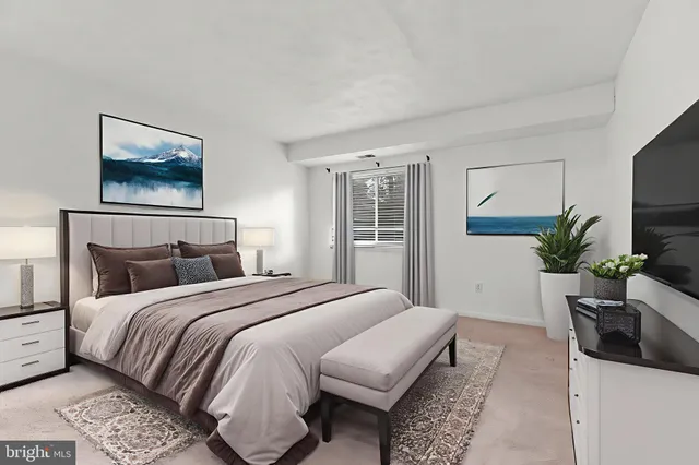 a bedroom with a bed a mirror and a potted plant