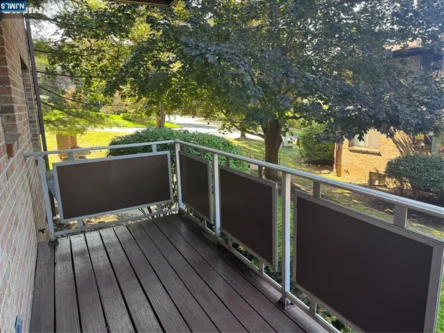 a view of balcony with wooden floor and fence