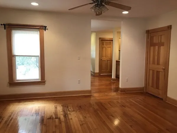 an empty room with wooden floor and a window