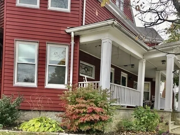 a view of a brick house with a flower garden