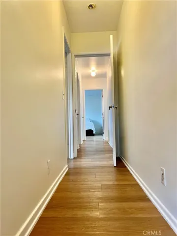 a view of a room with wooden floor and a bathroom