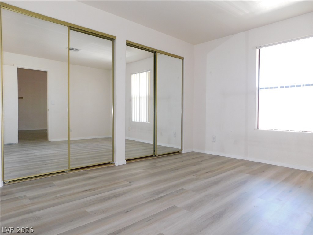 5221 South Lindell Road, Unit 202 Las Vegas, NV 89118 - Photo 11 of 28 Mirrored closet doors and light wood-look flooring define this bedroom's clean aesthetic.