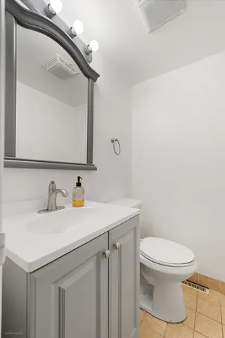 a bathroom with a toilet a sink and mirror