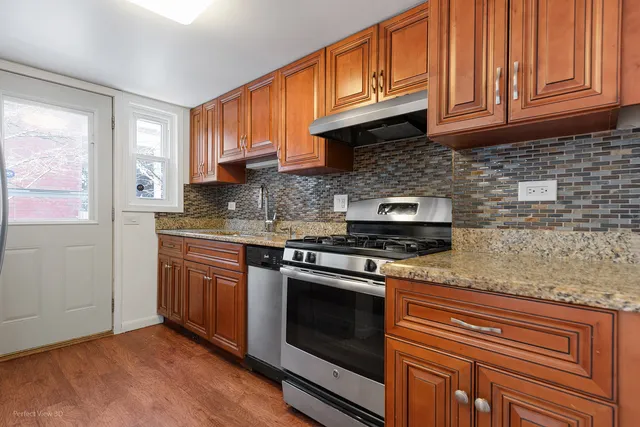 a kitchen with stainless steel appliances granite countertop a stove a sink and a microwave