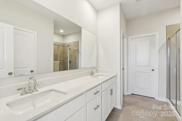 a spacious bathroom with a double vanity sink and a mirror