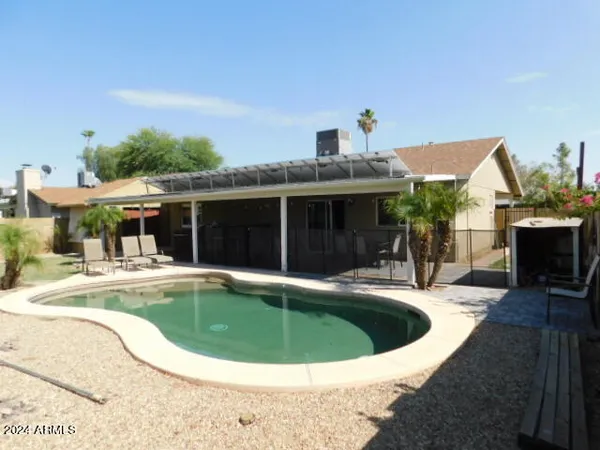 a view of a house with swimming pool and sitting area