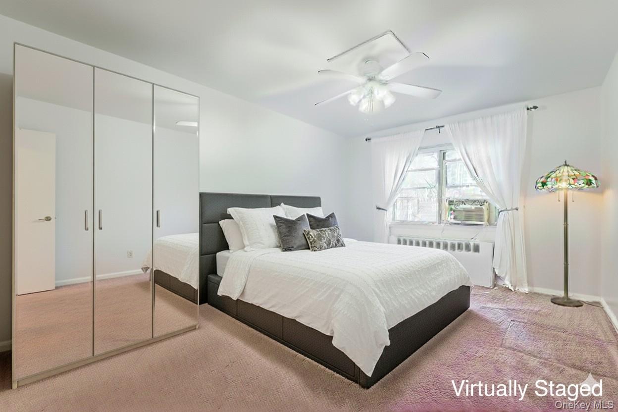 73-21 220th Street, Unit 139B2 Queens, NY 11364 - Photo 13 of 35 a bedroom with a large bed and a chandelier