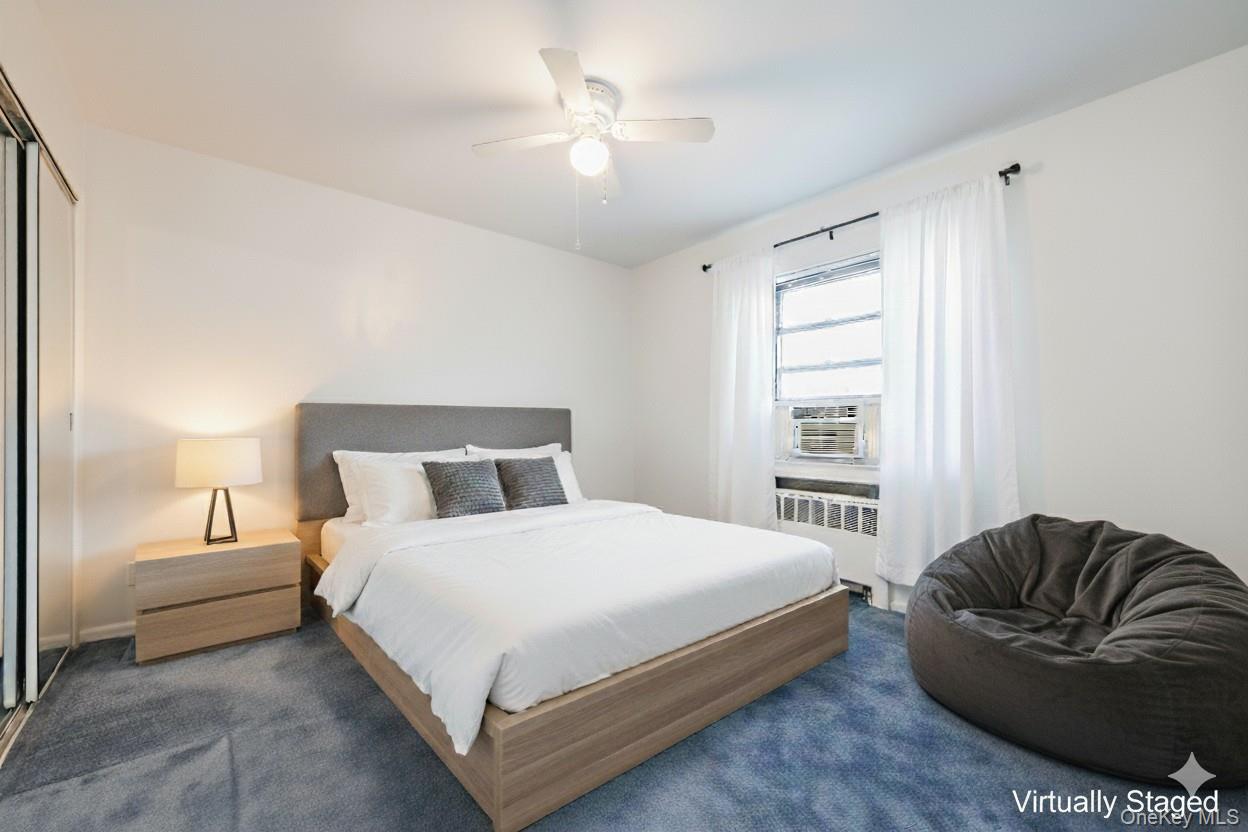 73-21 220th Street, Unit 139B2 Queens, NY 11364 - Photo 16 of 35 a bedroom with a bed couch and a ceiling fan