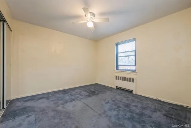an empty room with windows and ceiling fan