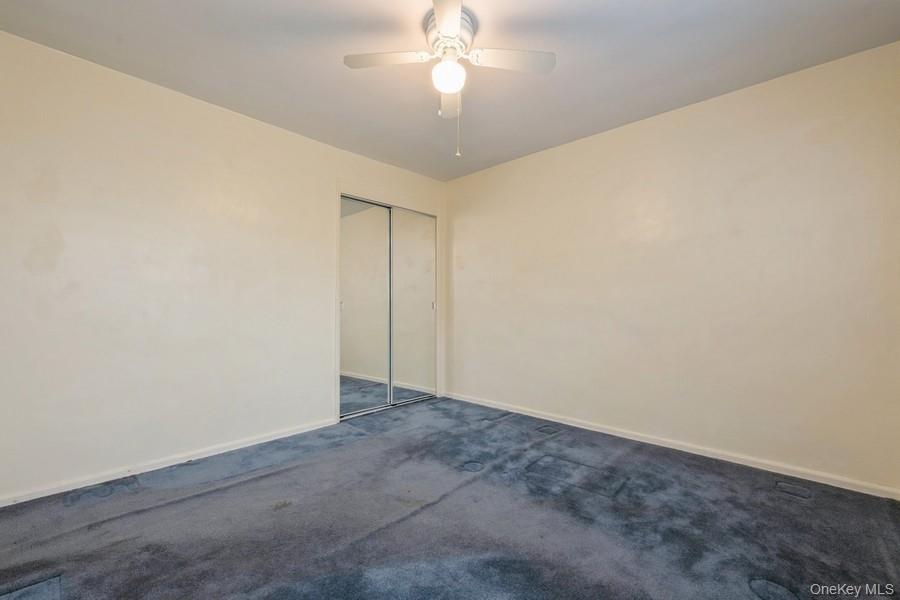 73-21 220th Street, Unit 139B2 Queens, NY 11364 - Photo 18 of 35 an empty room with a chandelier fan and closet area