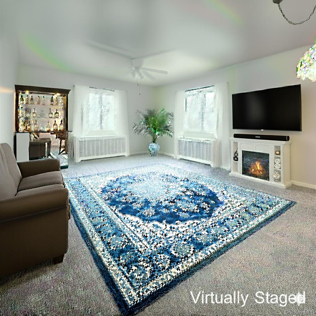 73-21 220th Street, Unit 139B2 Queens, NY 11364 - Photo 5 of 35 a living room with a couch a window and a flat screen tv