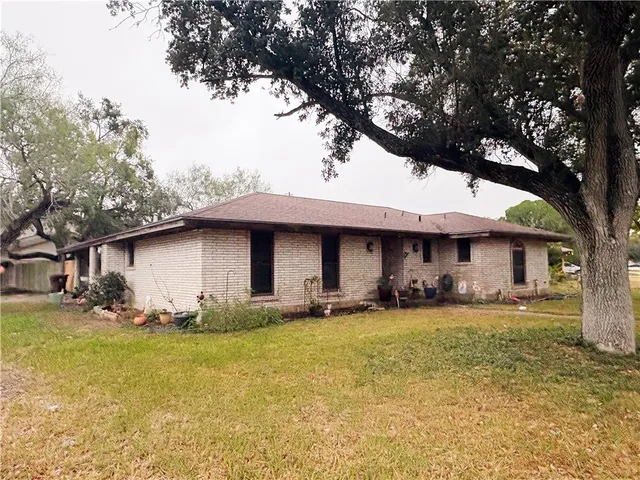 a front view of a house with yard and trees