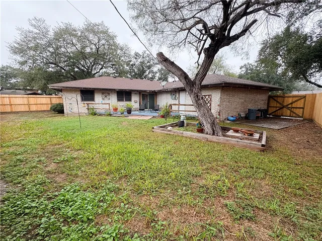 a front view of a house with a garden and trees