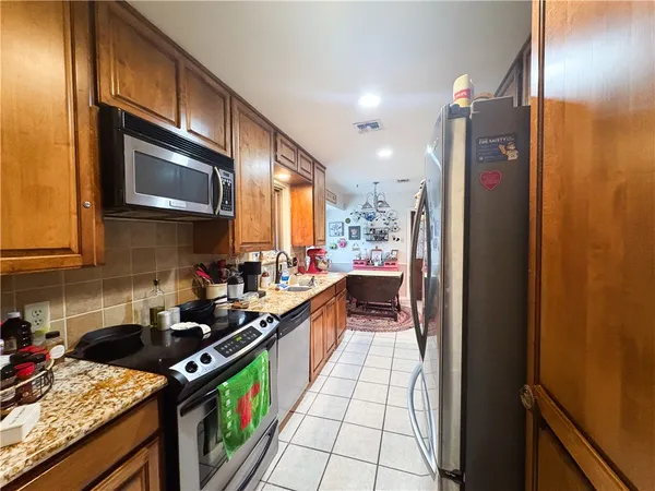 a kitchen with stainless steel appliances a stove a sink and a microwave