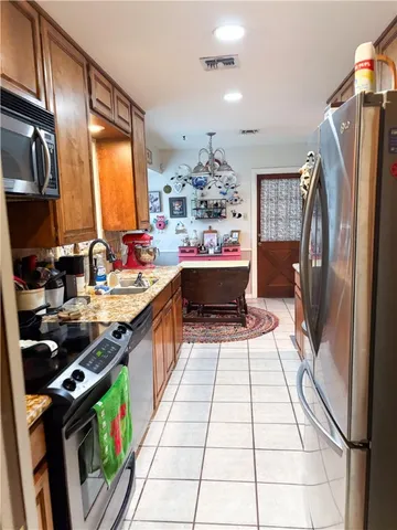 a kitchen with stainless steel appliances granite countertop a refrigerator a stove a sink and a microwave