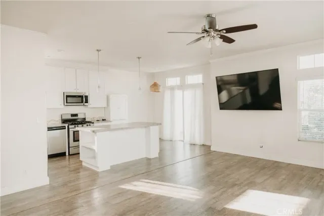 a kitchen with stainless steel appliances kitchen island granite countertop a stove a sink and a refrigerator