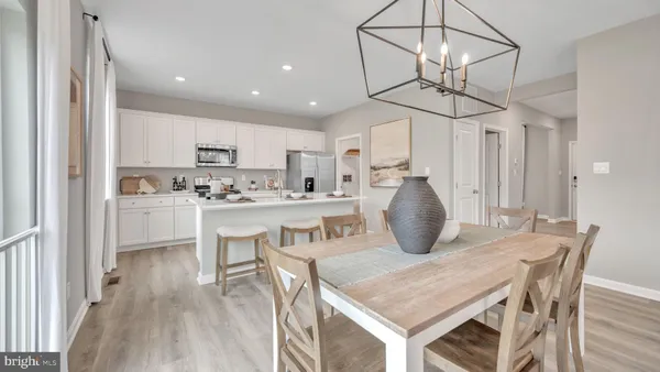 a kitchen with kitchen island a white table and chairs in it
